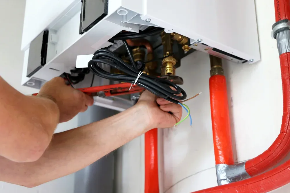 Plumber installing residential boiler system in Utah basement – Neighborly Plumbing