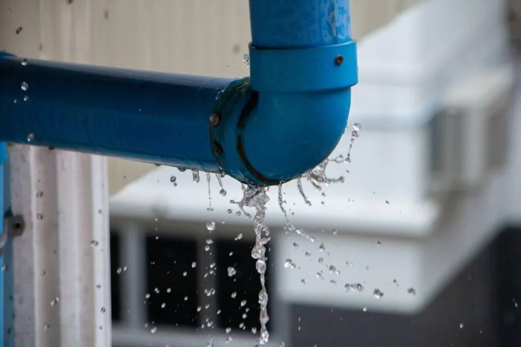 A blue pipe releasing water, showcasing the movement of liquid as it flows from the pipe