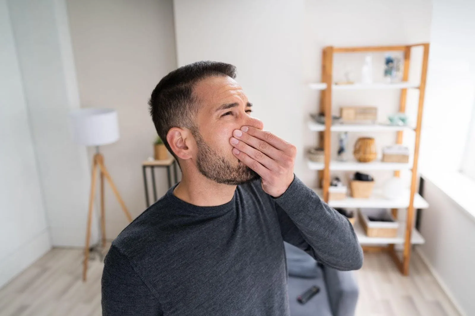 A man is cupping his hand over his mouth and nose, possibly in a gesture of surprise or contemplation